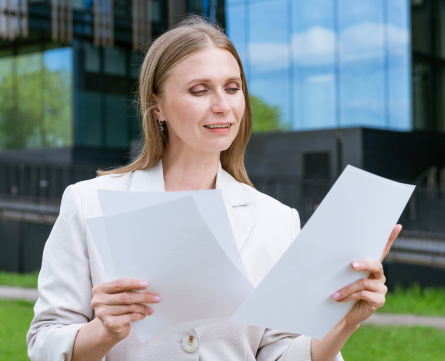 beautiful young suburban business woman walking classic urban office buildings holding paper docu 1